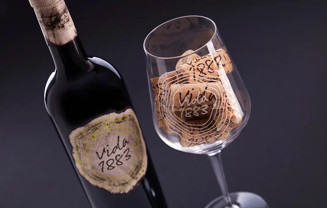 Detalle de la etiqueta y una copa serigrafiada con el diseño realizado por microbio agencia creativa